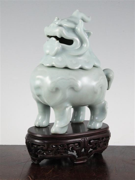 A Chinese celadon-glazed lion-dog censer and cover, 18th century, 17.2cm, wood stand